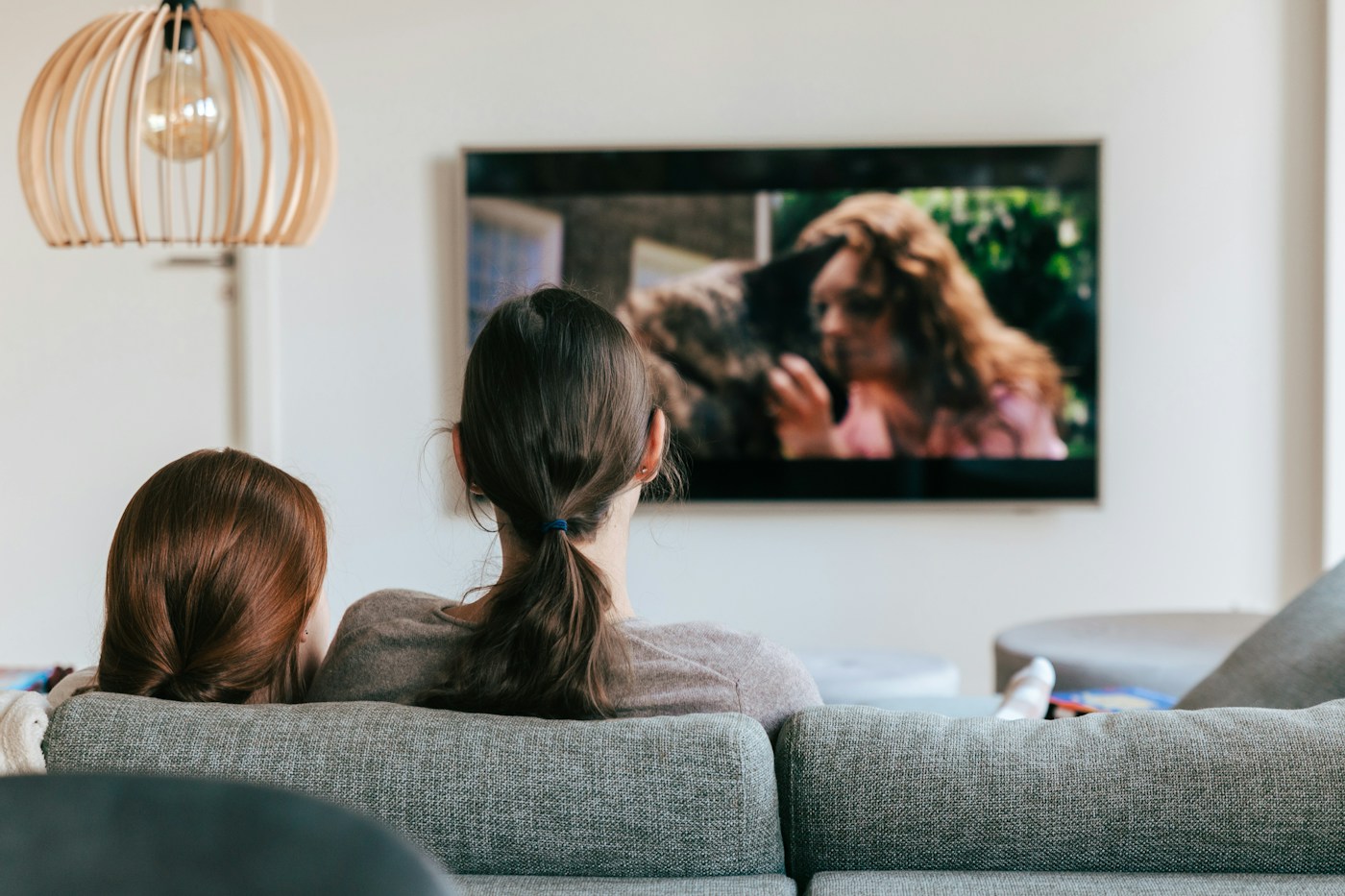 Pessoas assistindo à televisão juntas na sala de casa